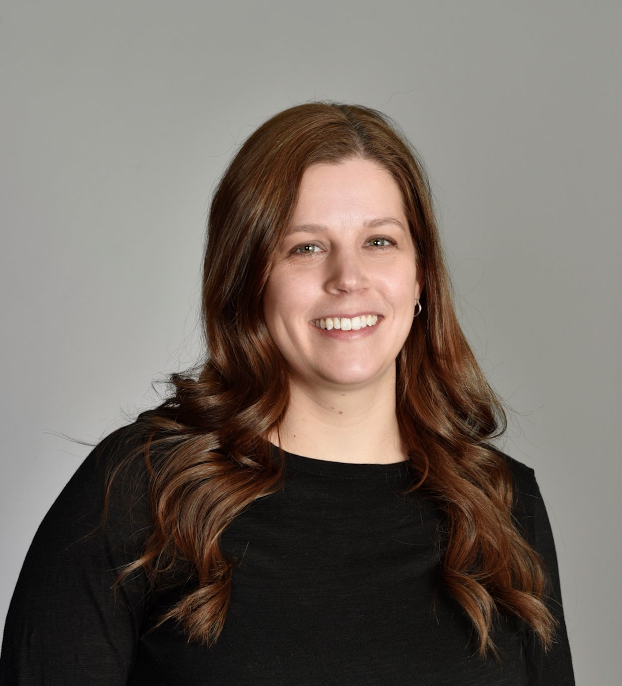woman with long hair smiling and posing for a picture