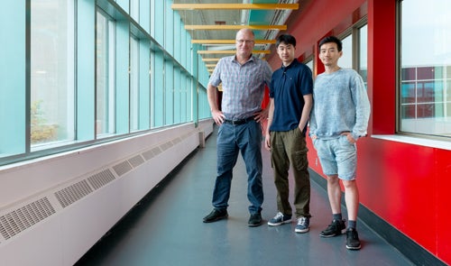 From left to right: Jesse Hoey, Steven Feng, and Aaron Li pose for a portrait in the Davis Centre overpass.