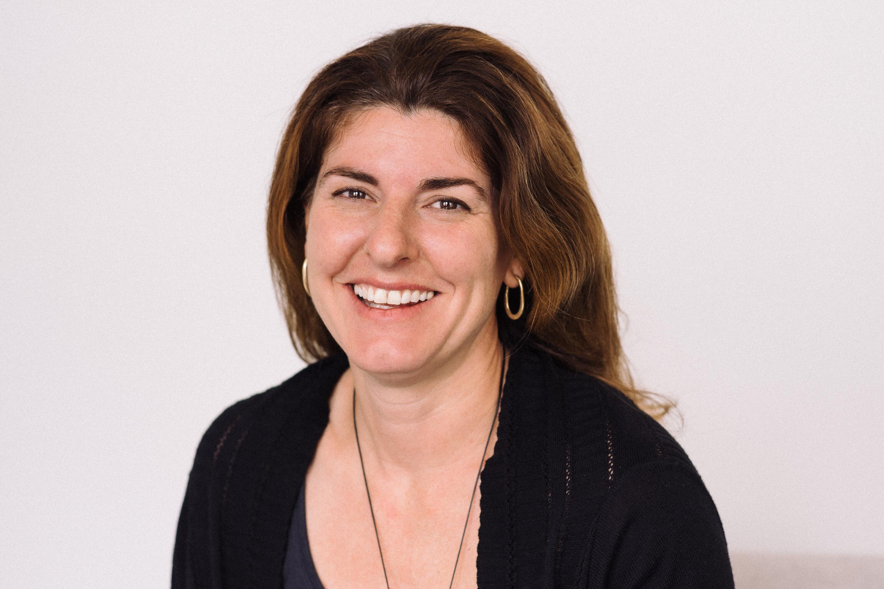 head shot of woman with long dark hair smiling