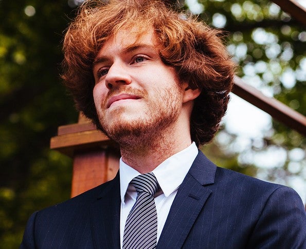 man with ginger hair standing and smiling