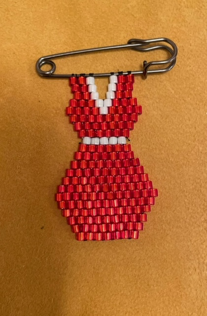 Red Dress beadwork on a pin
