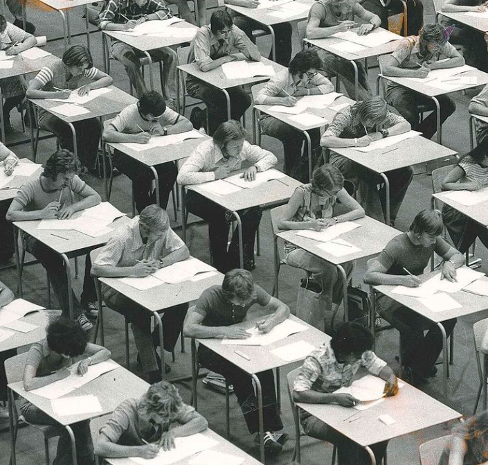 Students writing exams at tables