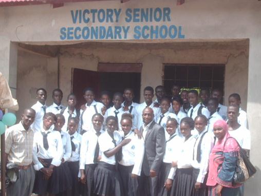 Group photo outside Victory Senior Secondary School entrance.
