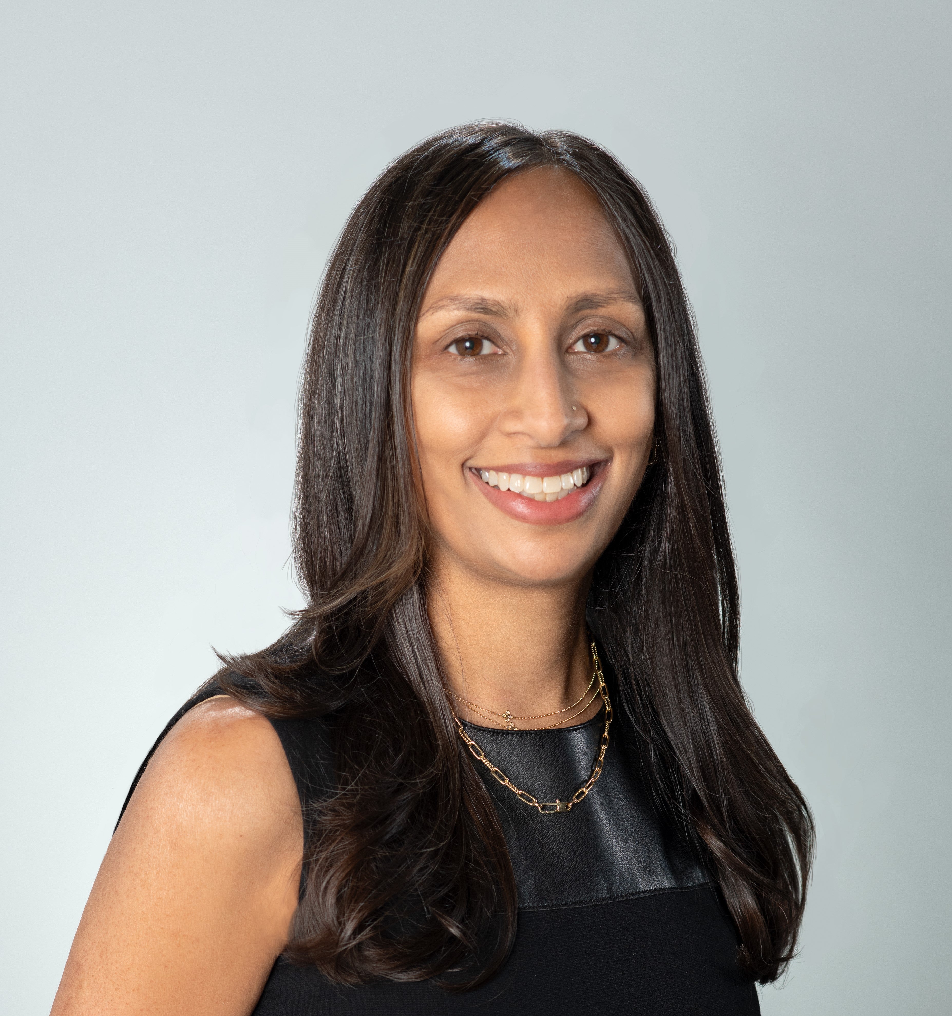 headshot of woman with long dark hair smiling wearing a black top