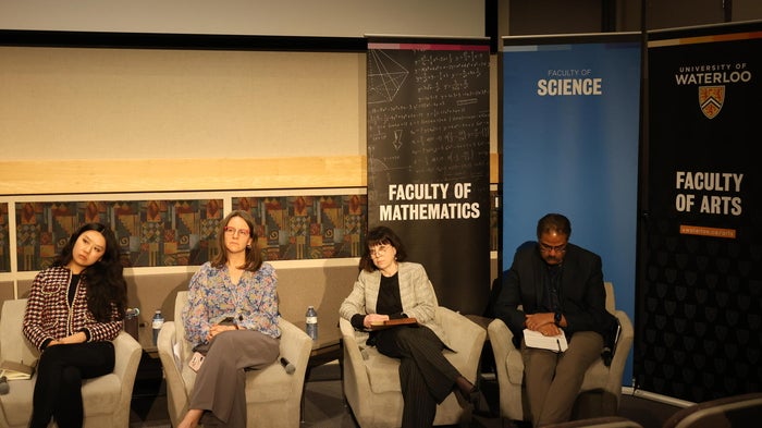 The four panelists sitting on chairs 