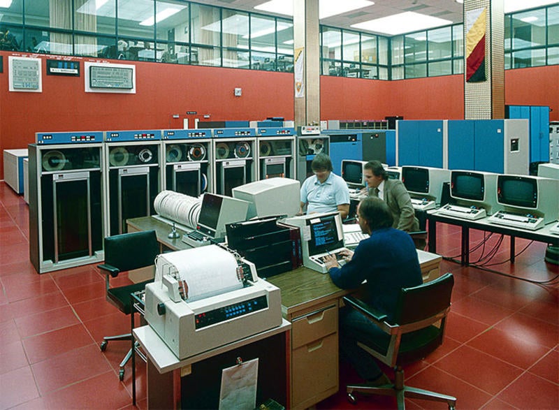 Men work at computers in the red-coloured Computer Centre
