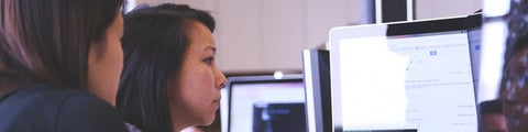 Two people staring at computer screen