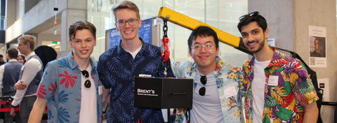 Portrait of 4 students standing with their capstone project