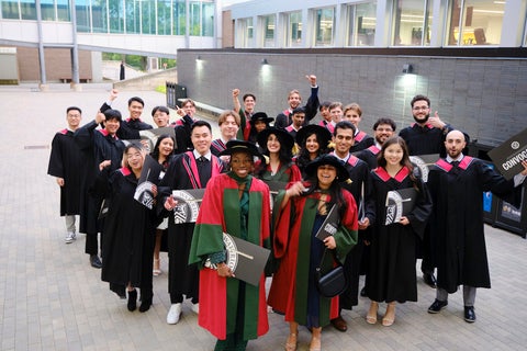 Graduands posing for a group picture outside. 