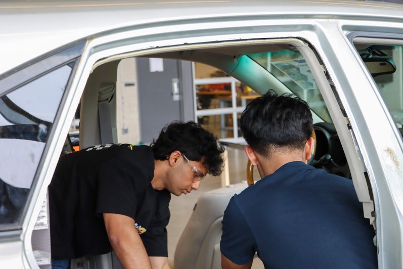 Students taking apart the interior of a car