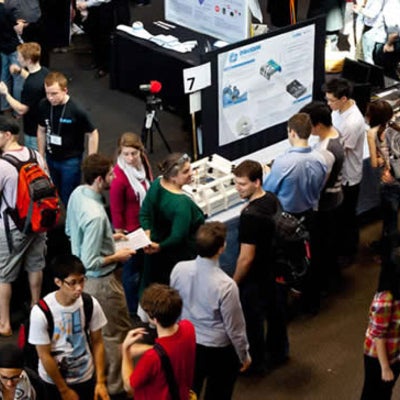 Many people presenting their design projects at booths