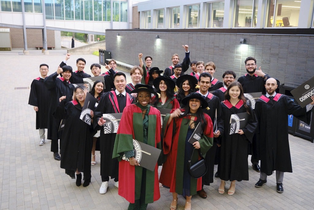 Graduands posing for a group picture outside. 