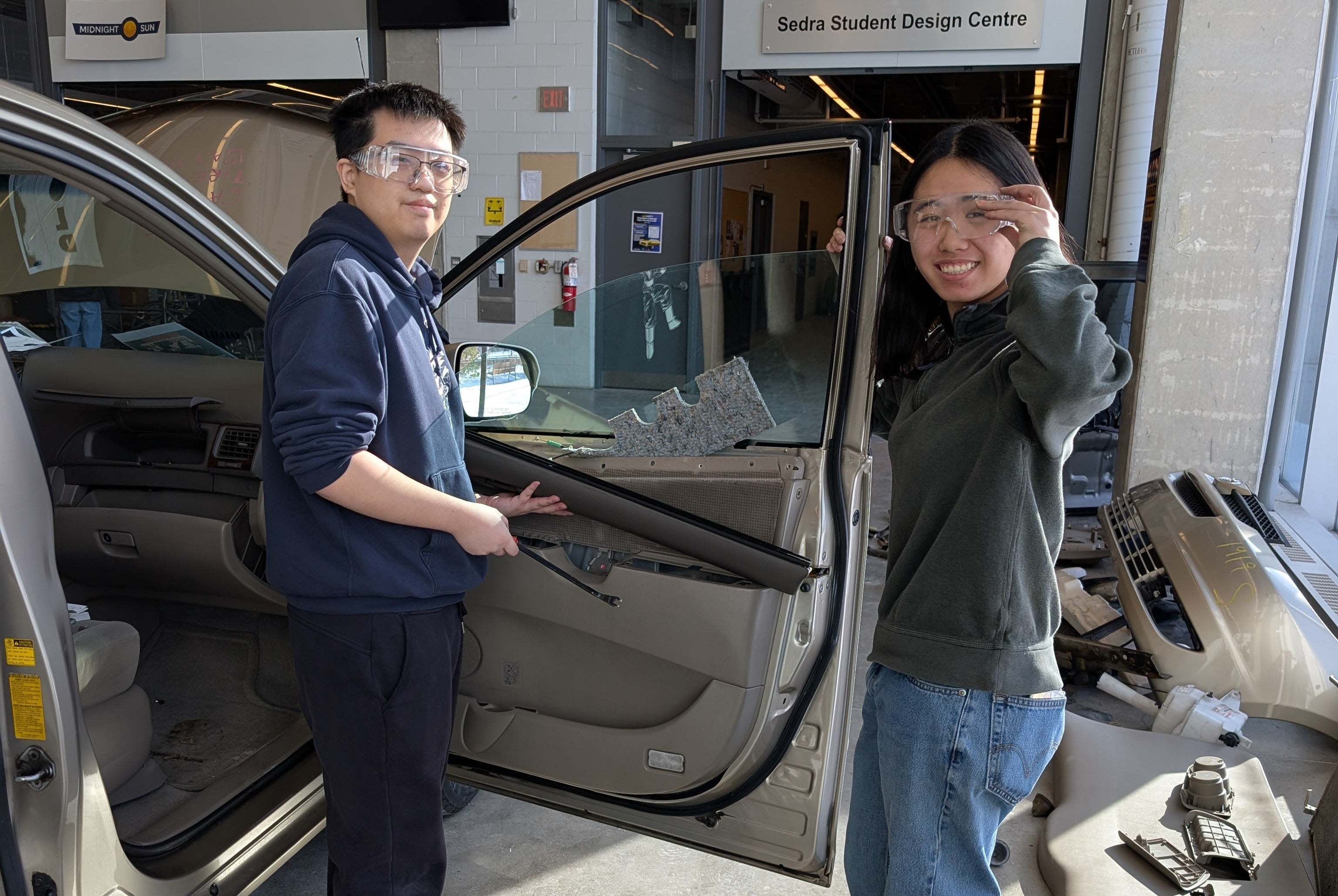 Two students posing for a picture at an engineering car dissection session