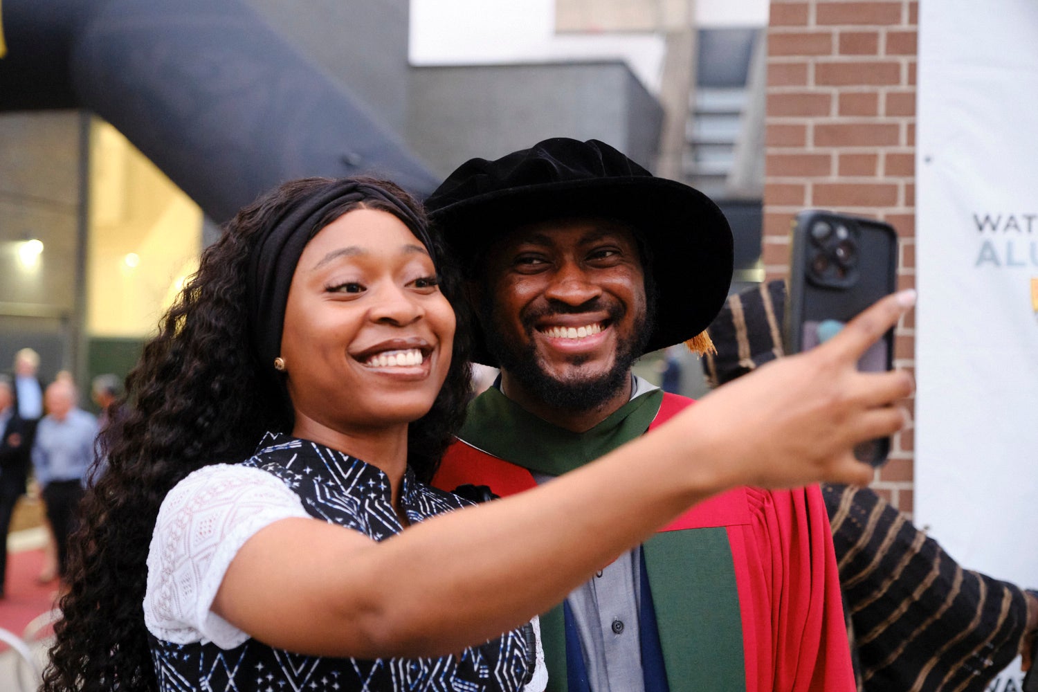 PhD graduate and supporter taking a selfie outside after convocation.