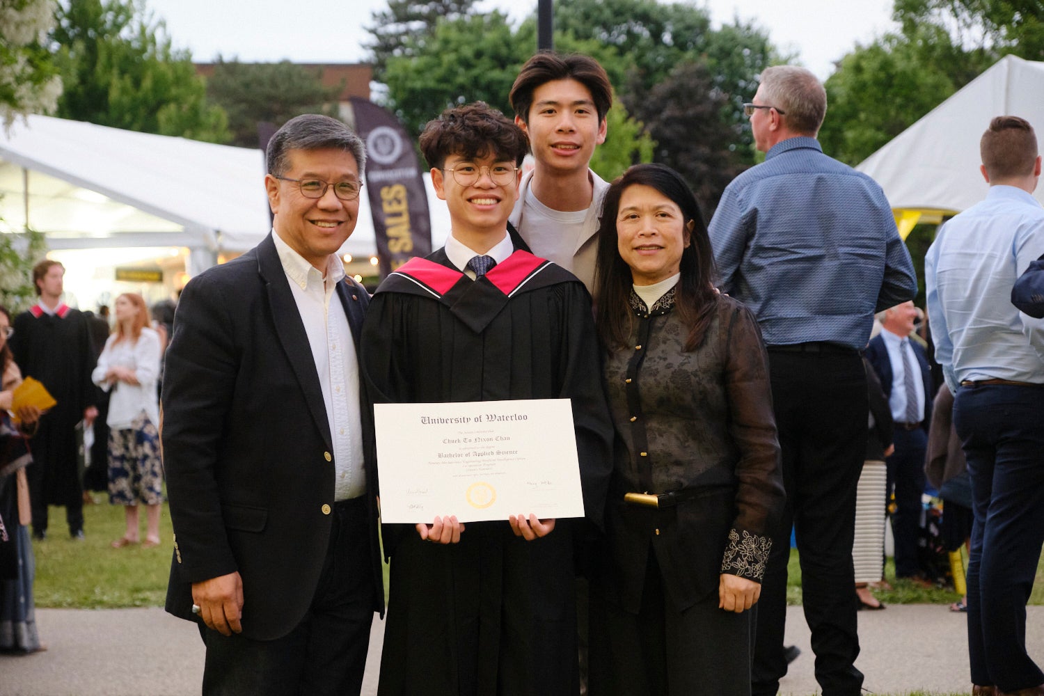 Graduate and his family posing for a picture outside after convocation. 