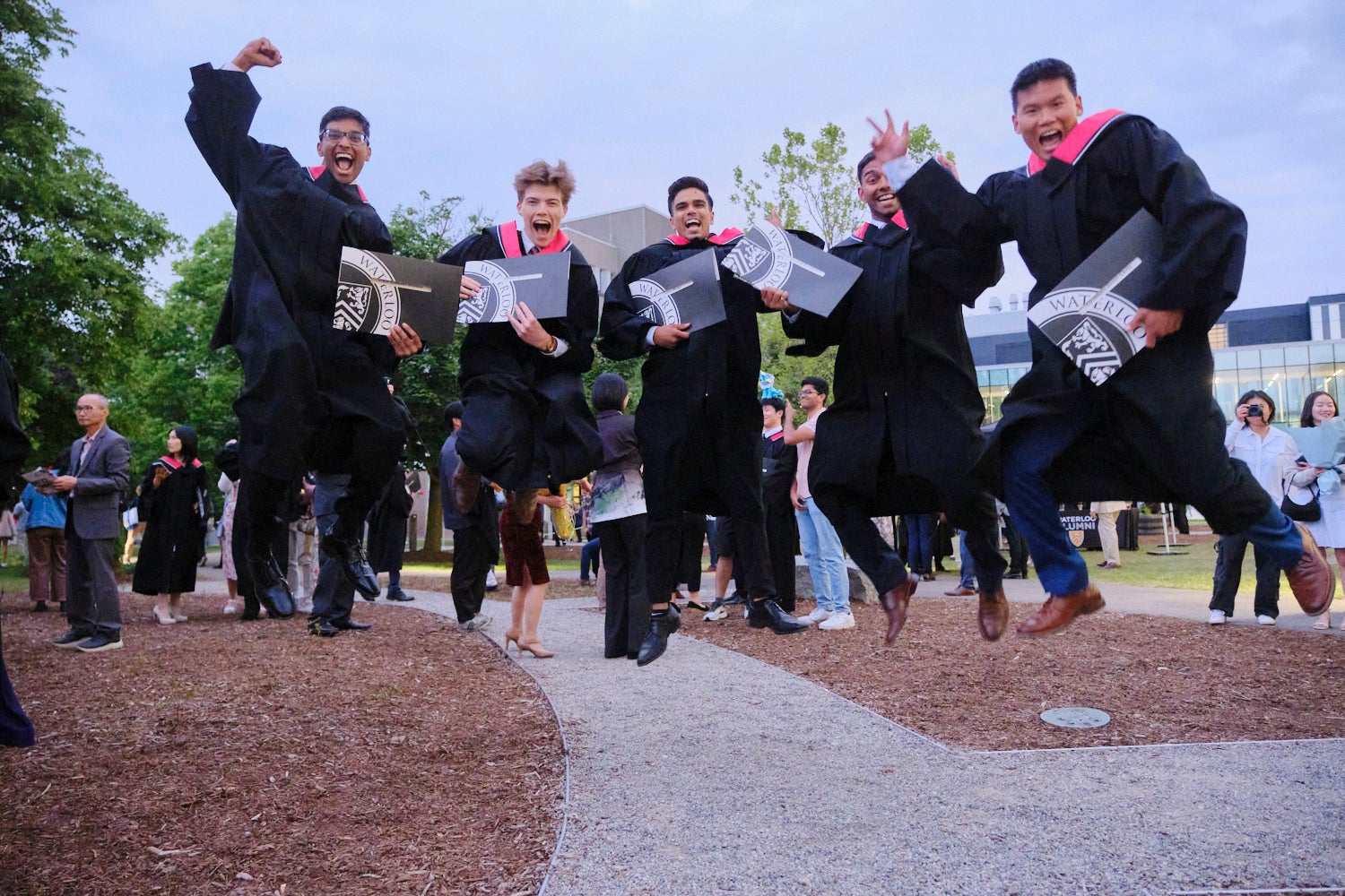 Graduates jumping with their degrees