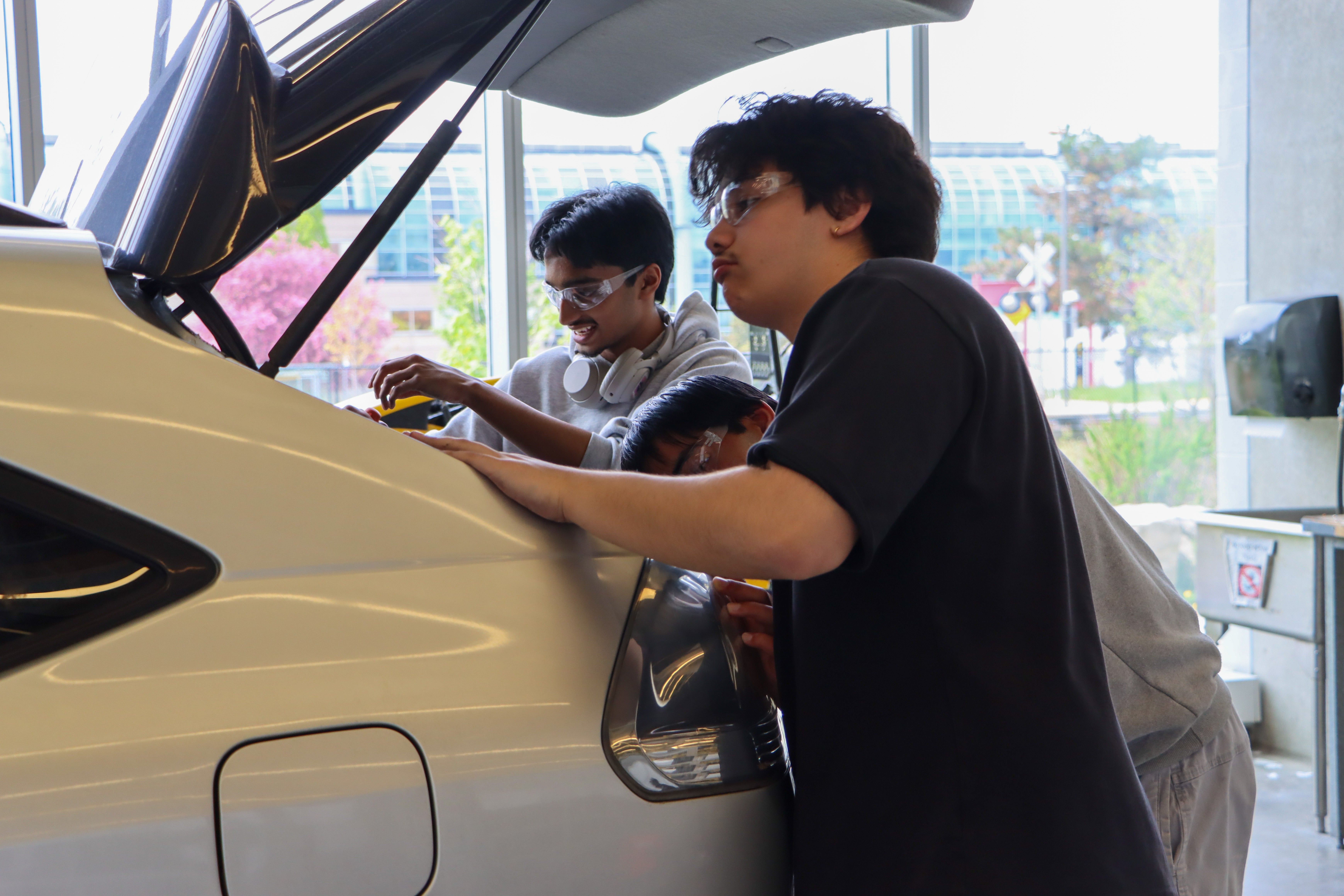 Students taking off the trunk of a car