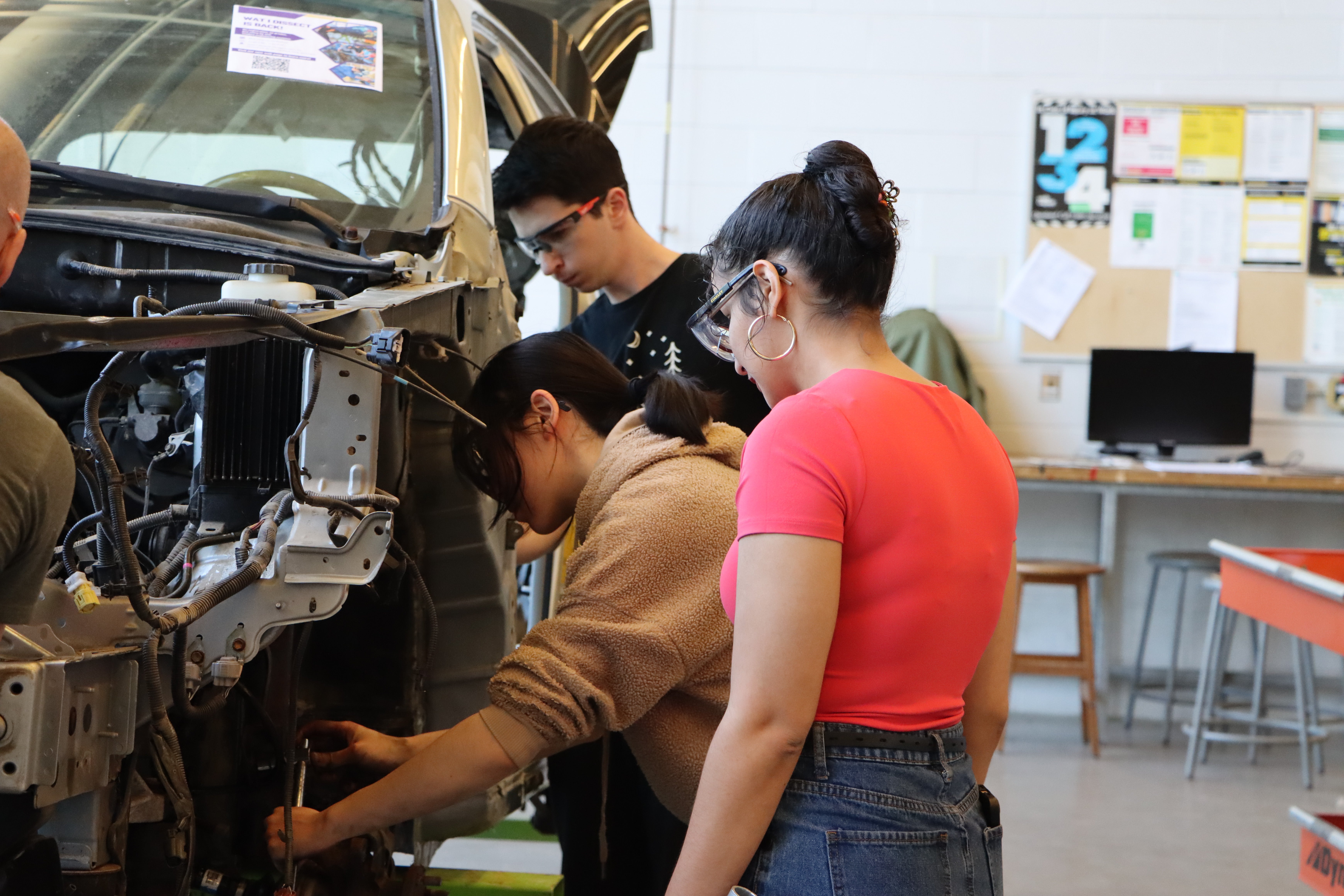 Students working at the wheels of a car