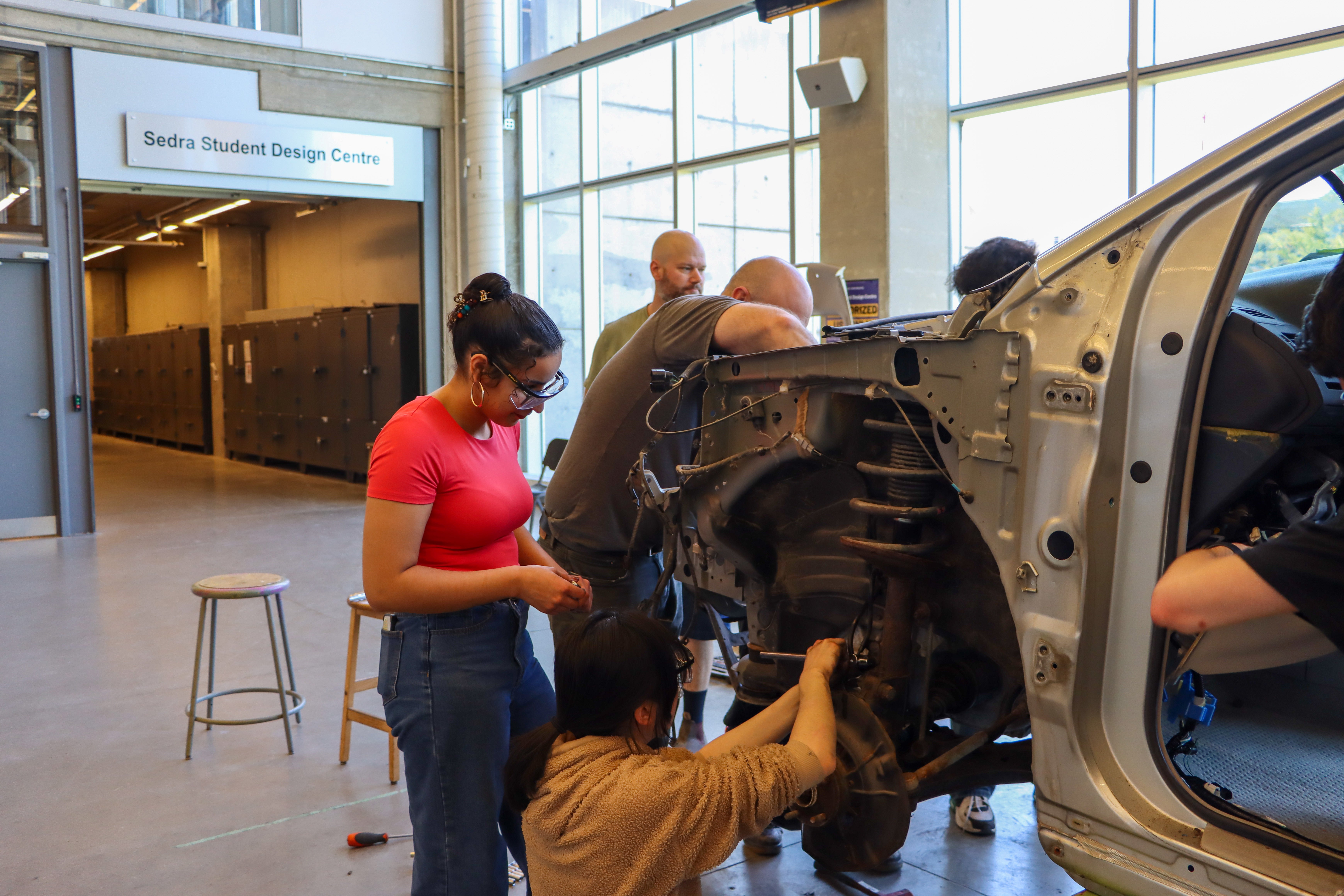 Students working at the wheels of a car