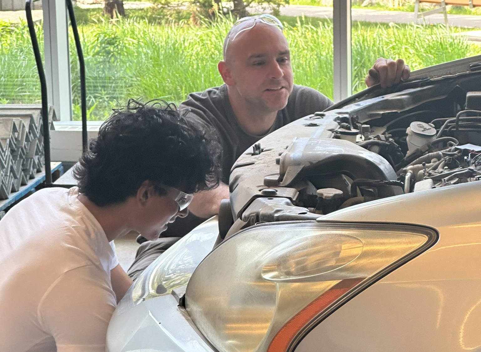Student and staff member working on car