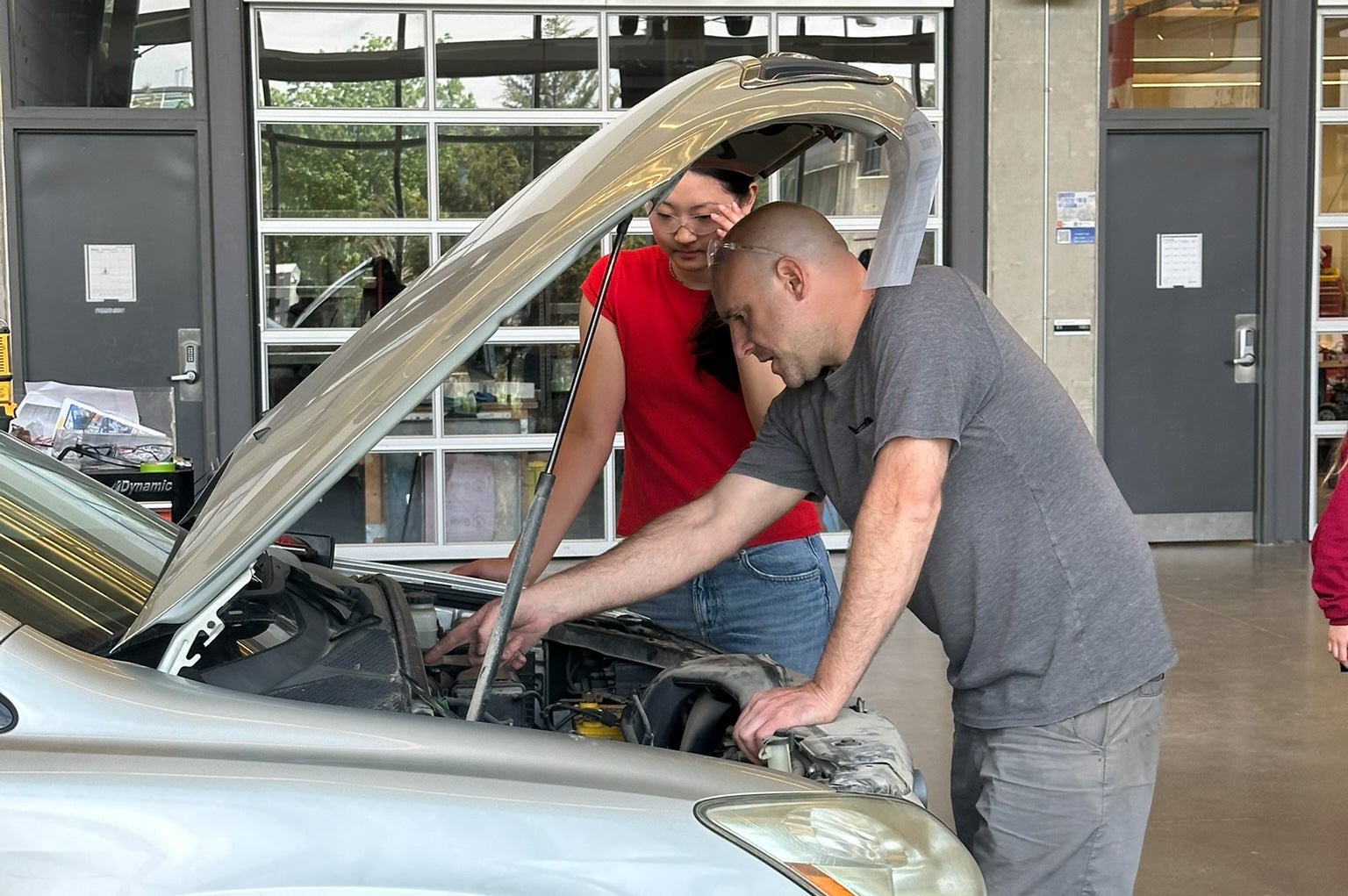 Student and staff member working on car