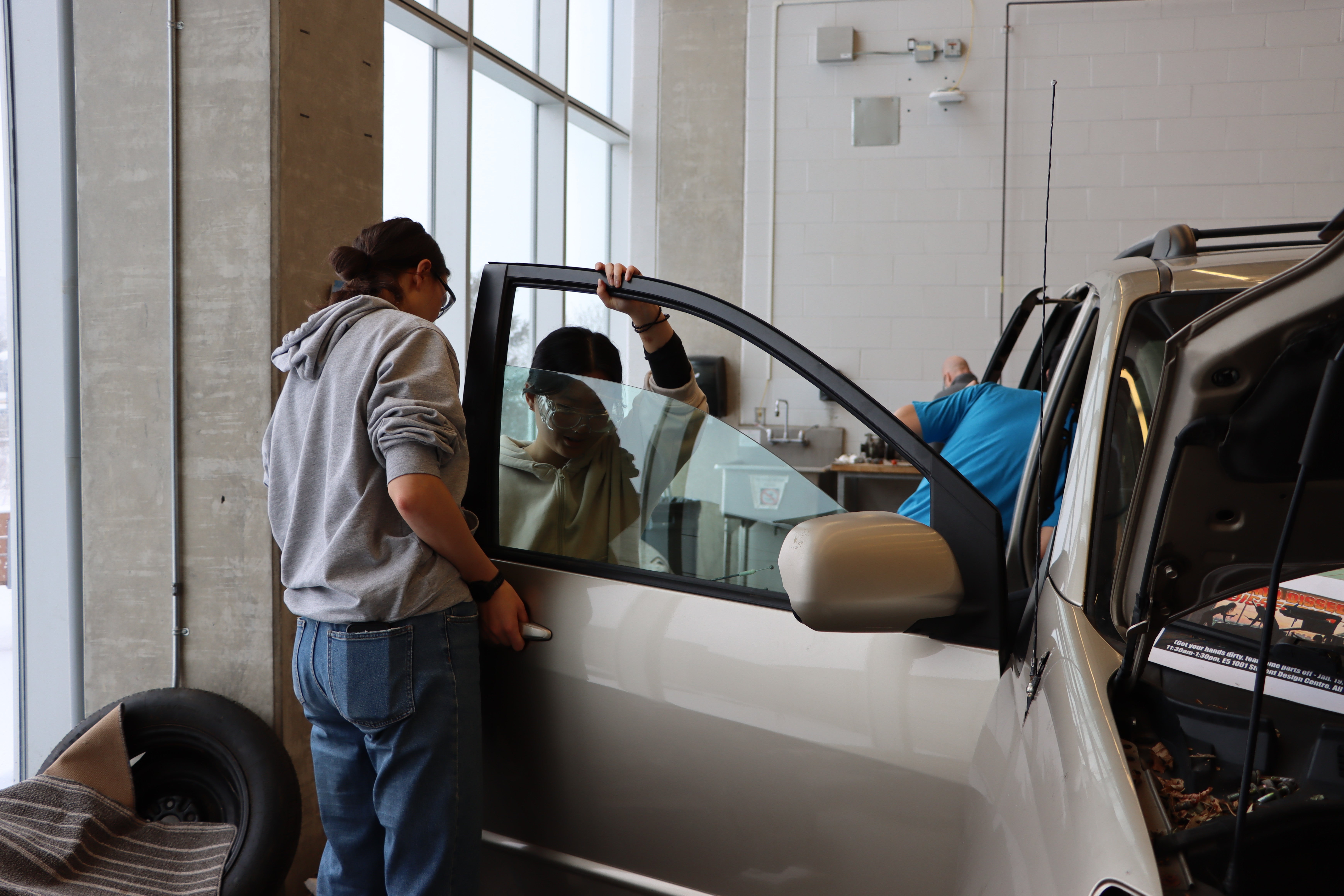 Students taking off the door of a minivan. 