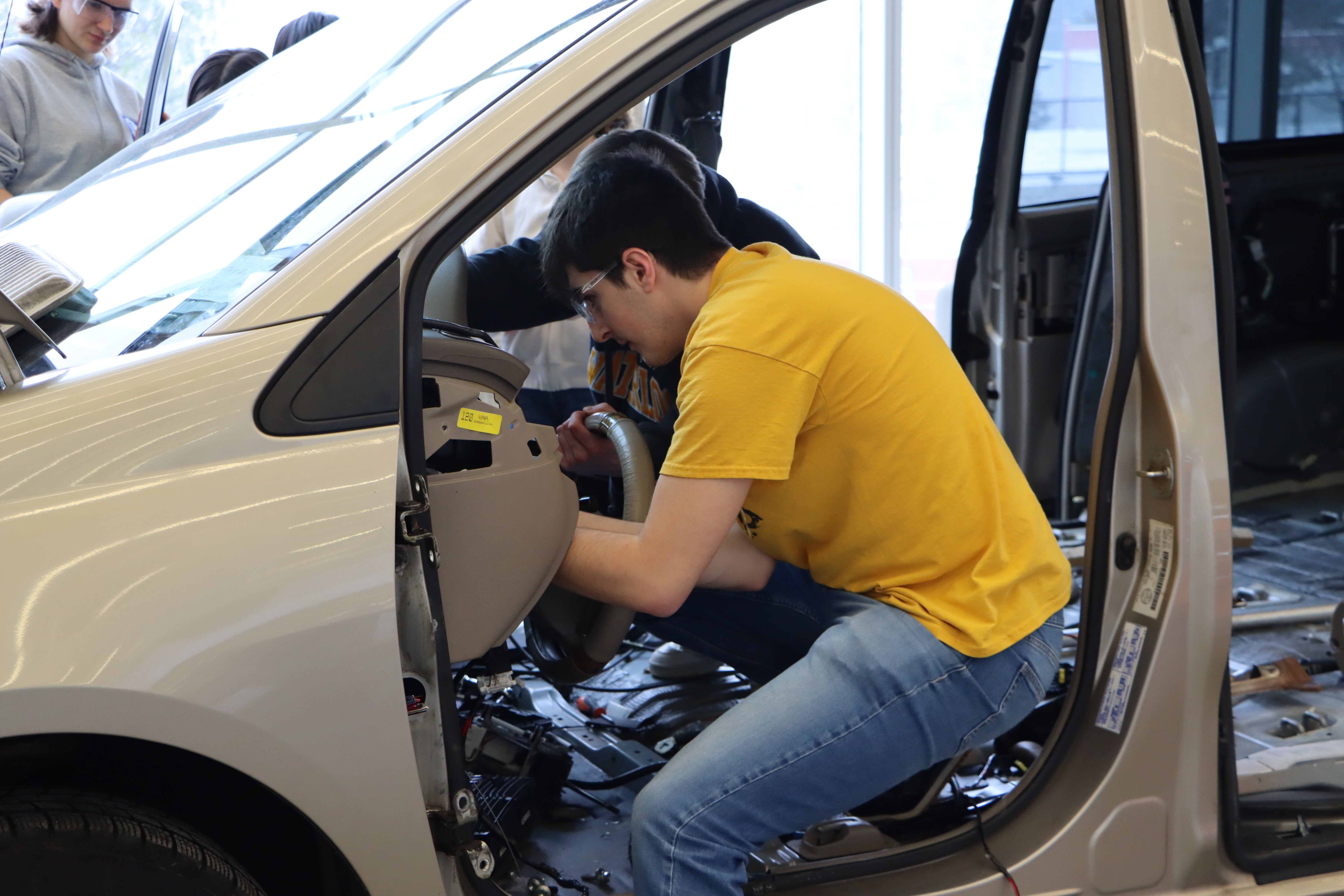 Students taking out the interior of a minivan. 