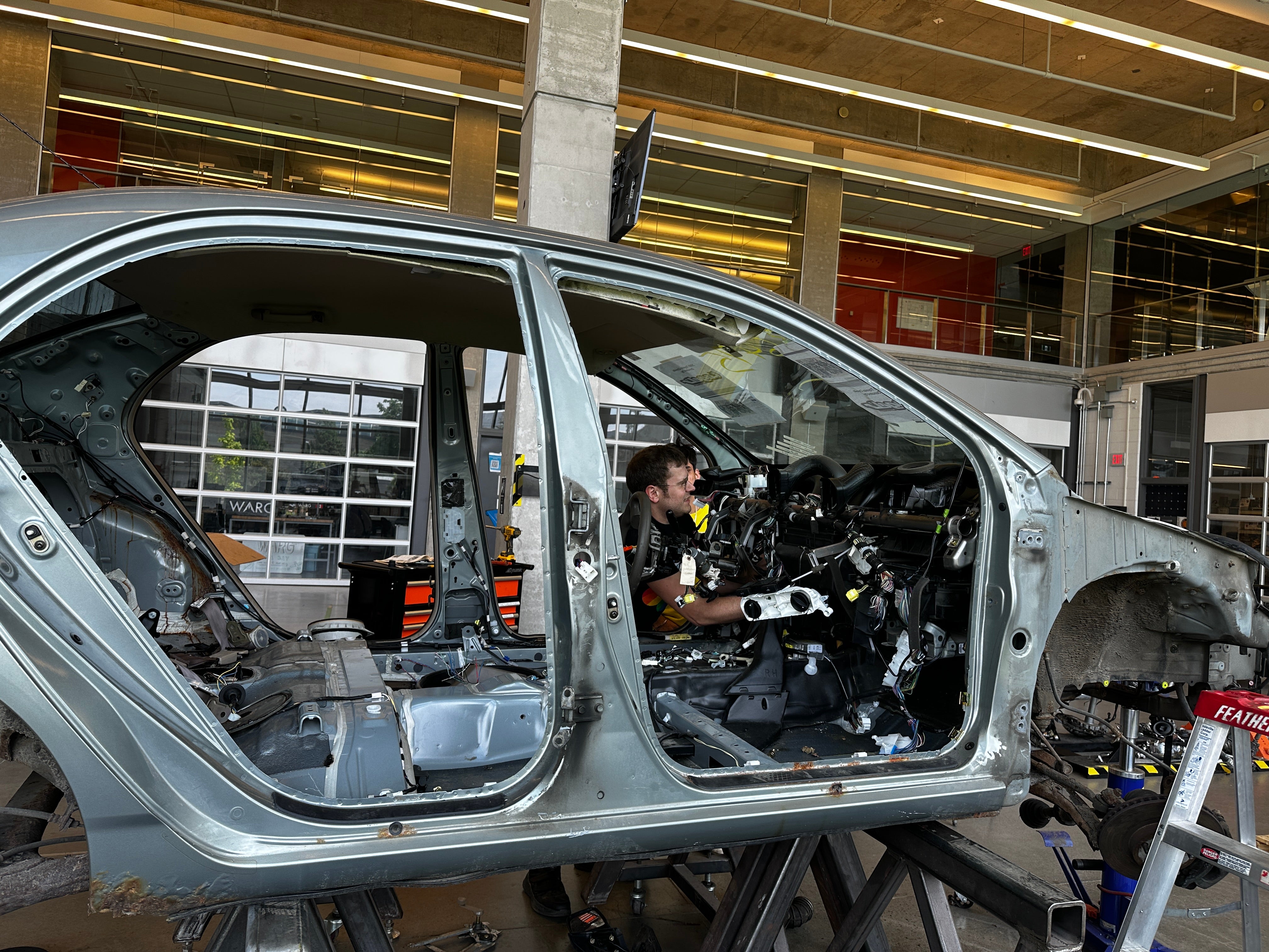 Stripped down car with a student working in it