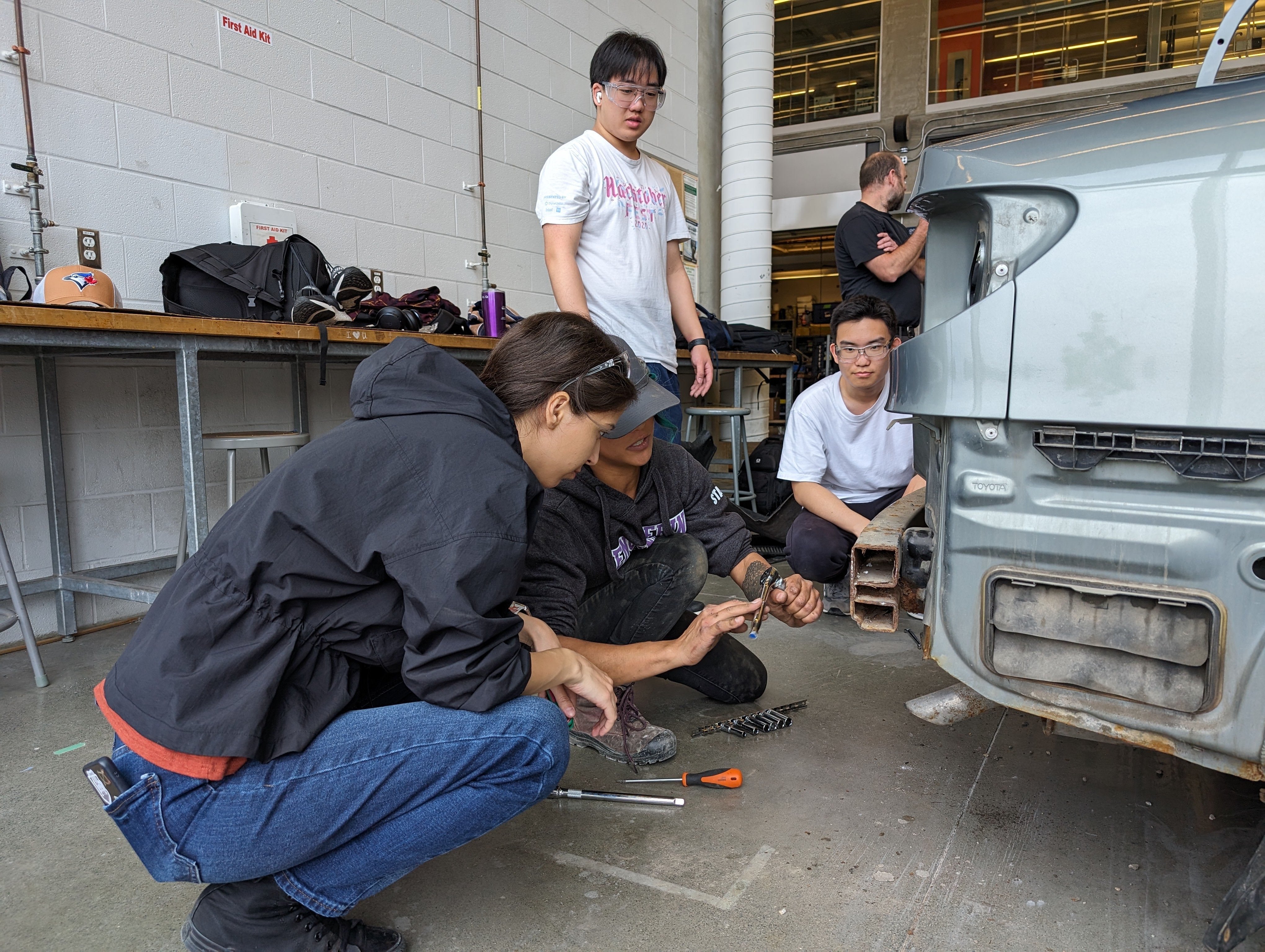 Students examining a car