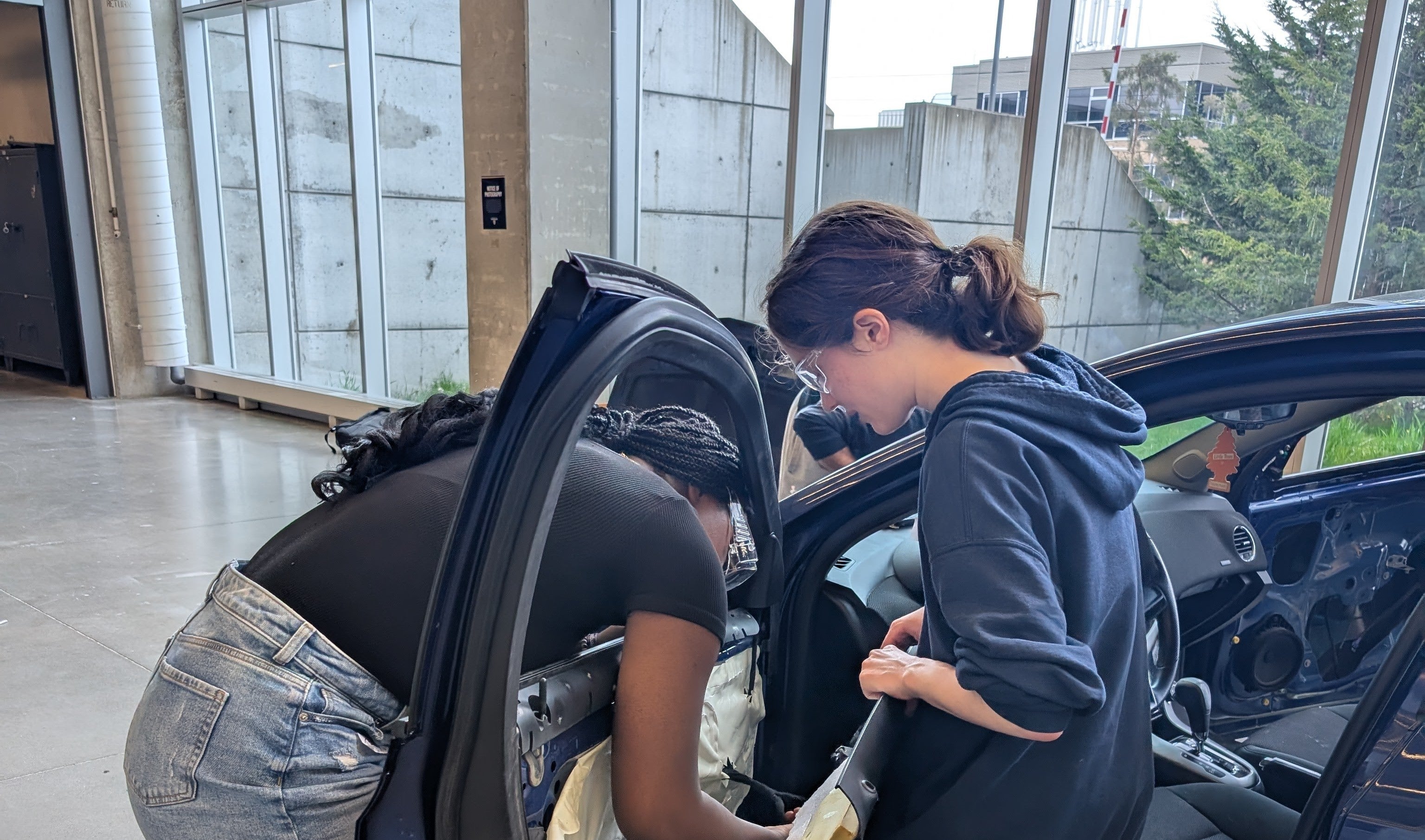 Two students disassembling a car door