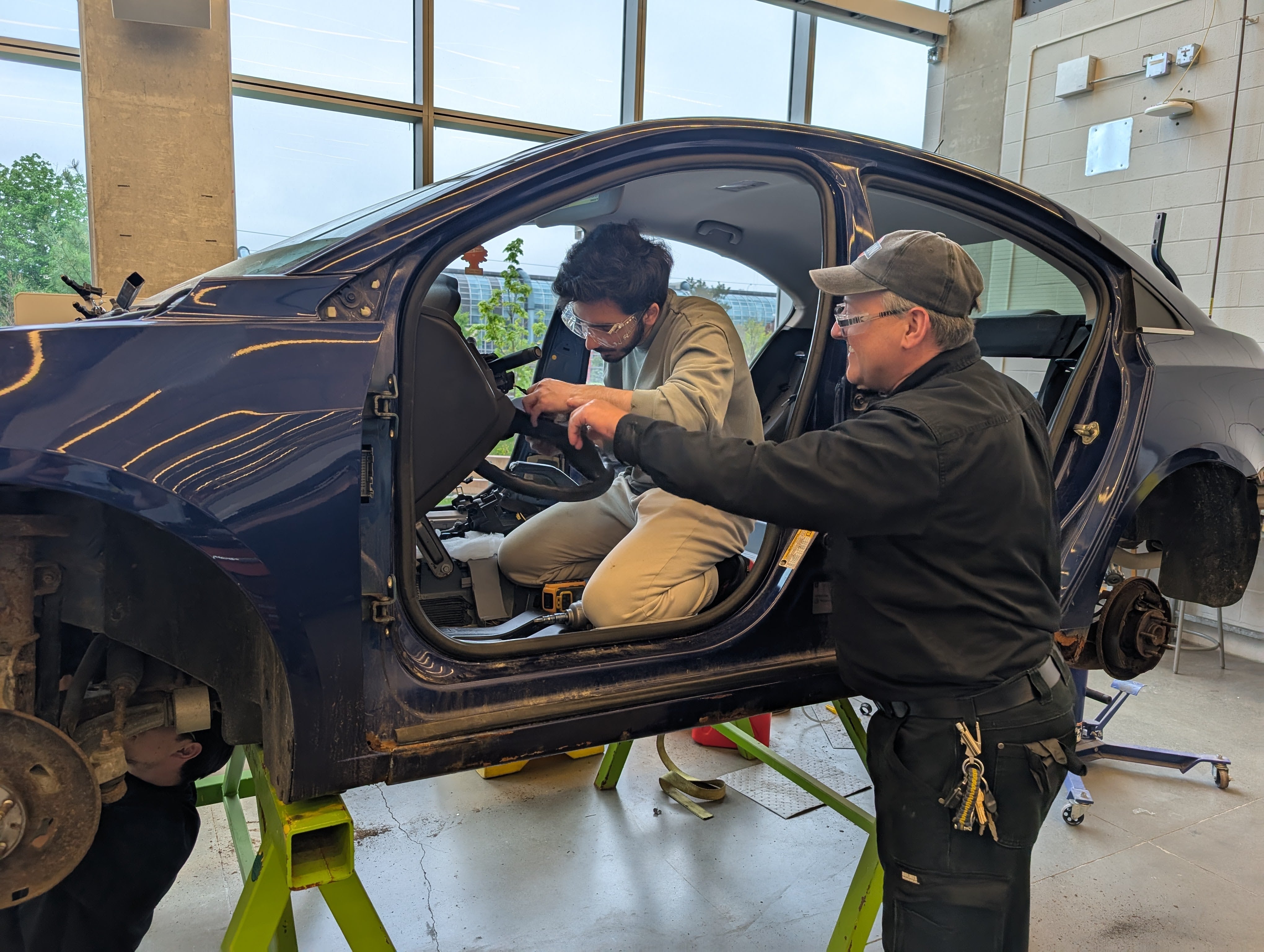 A student and a mentor taking a part a car