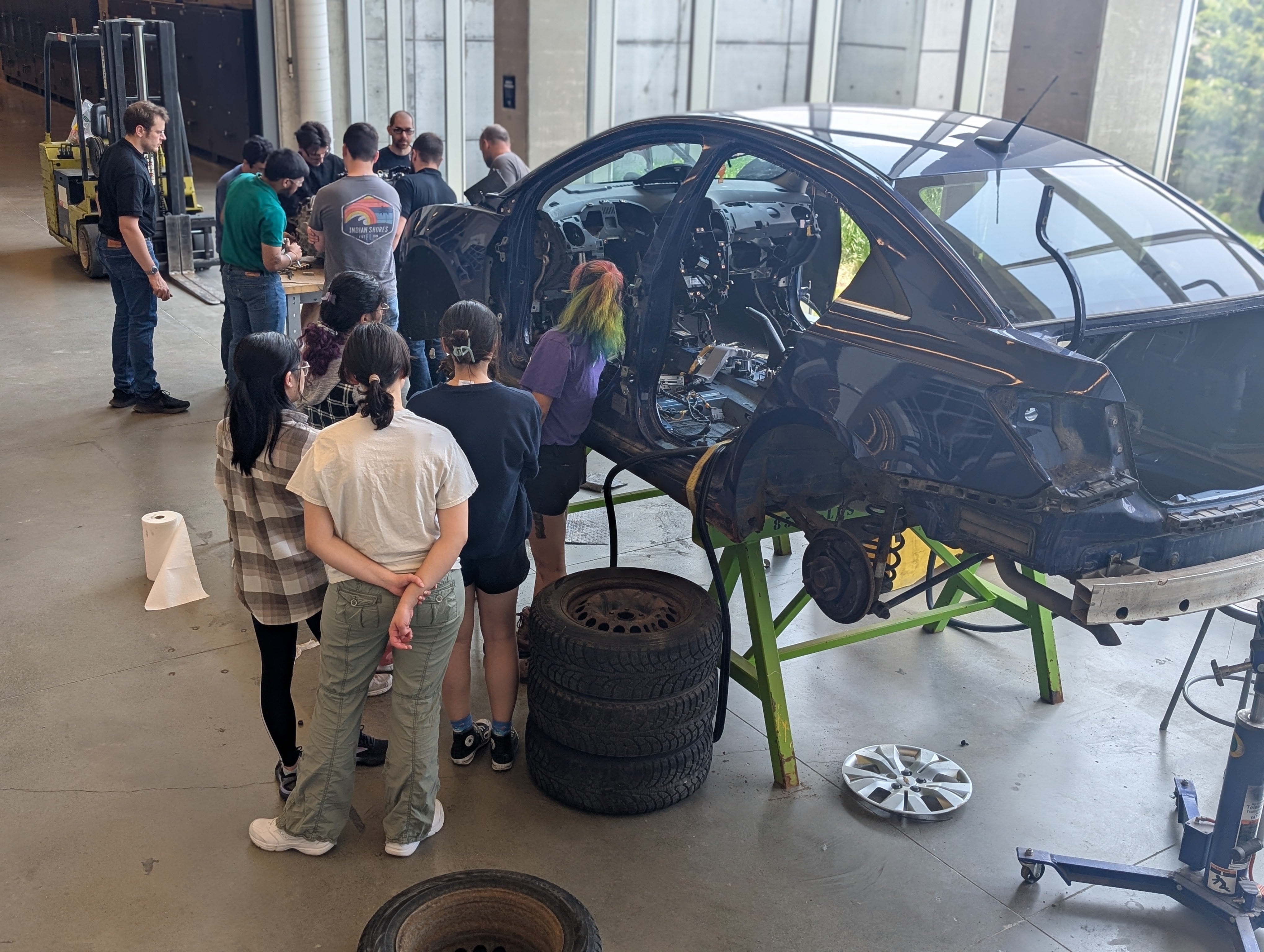 Group of students taking apart a car