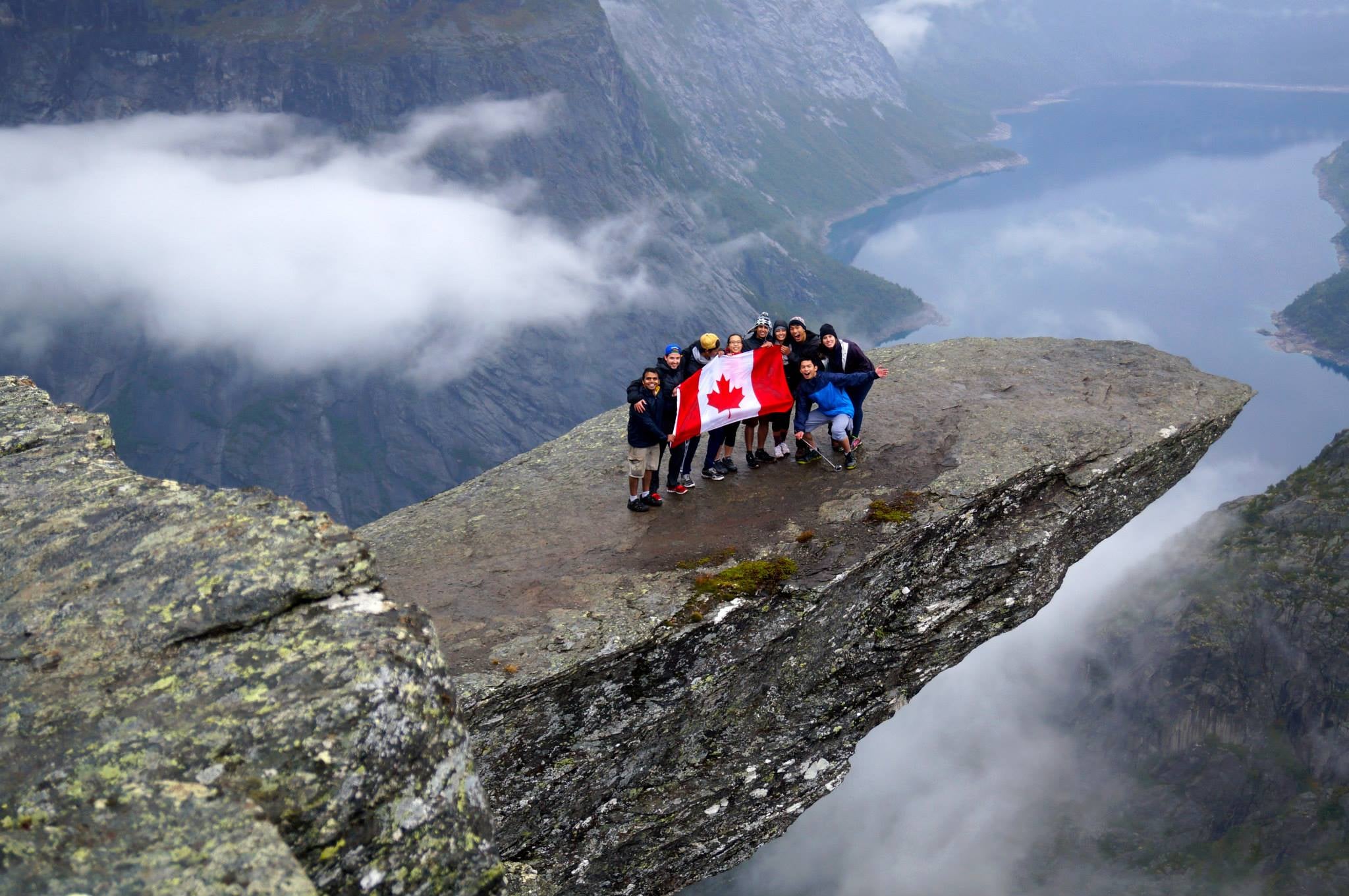 Students holding Canadian flag on a mountain in Norway
