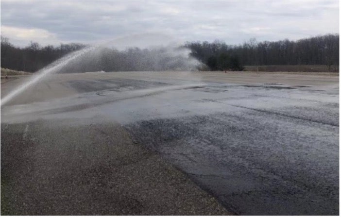 Water being sprayed on large paved area