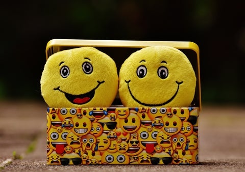 Smiling emoji stuffed animals in a box