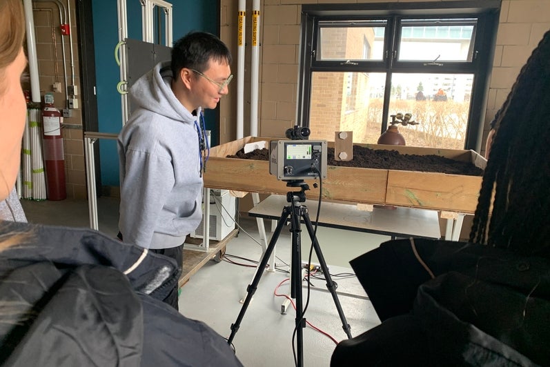 Team member Mu-An Tsai talks to participants about the TDLAS system.