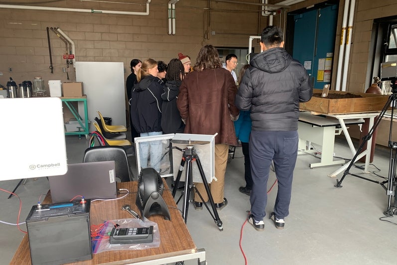 Participants huddle around the TDLAS system to see it working.
