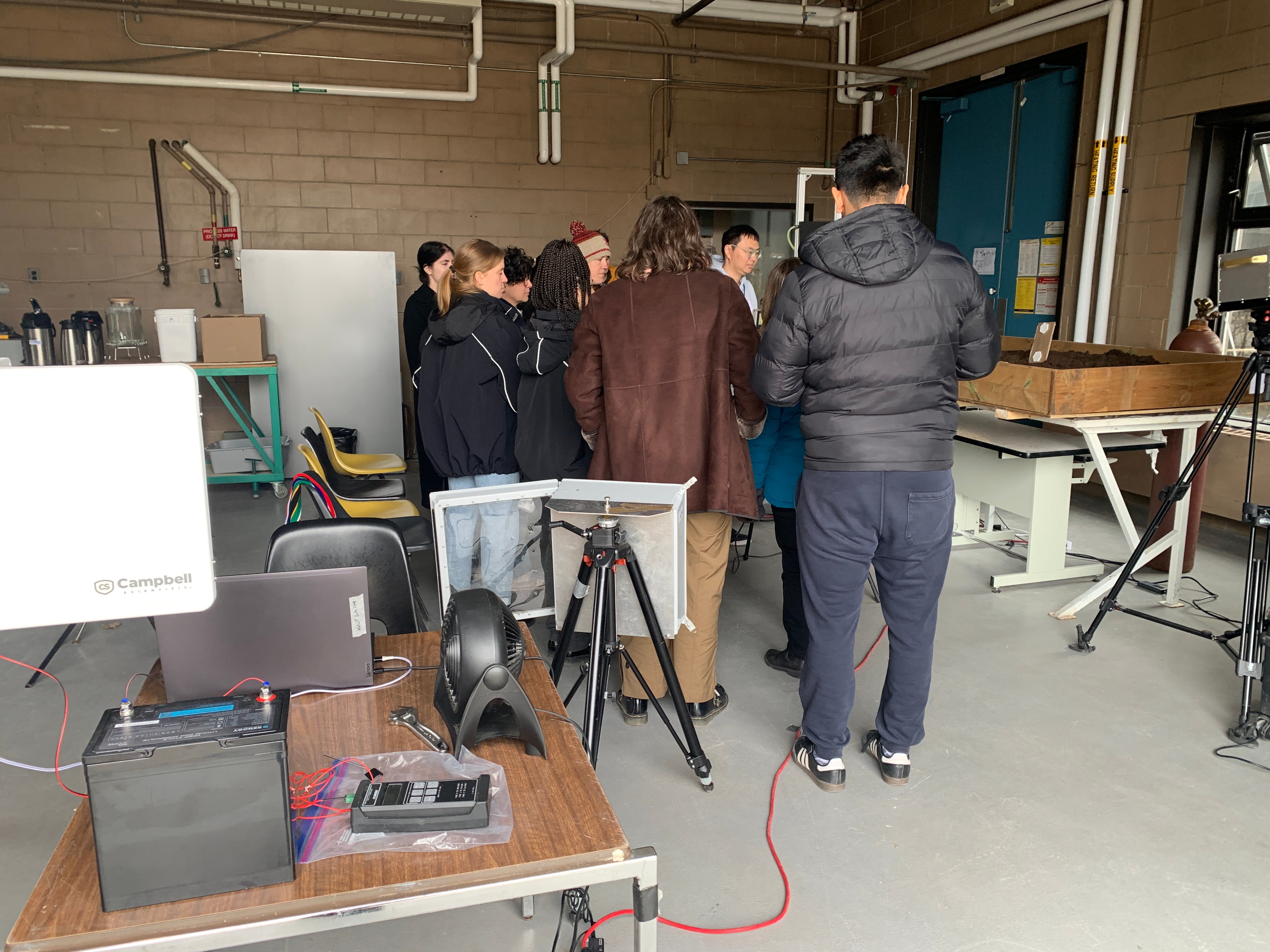 Participants huddle around the TDLAS system to see it working.