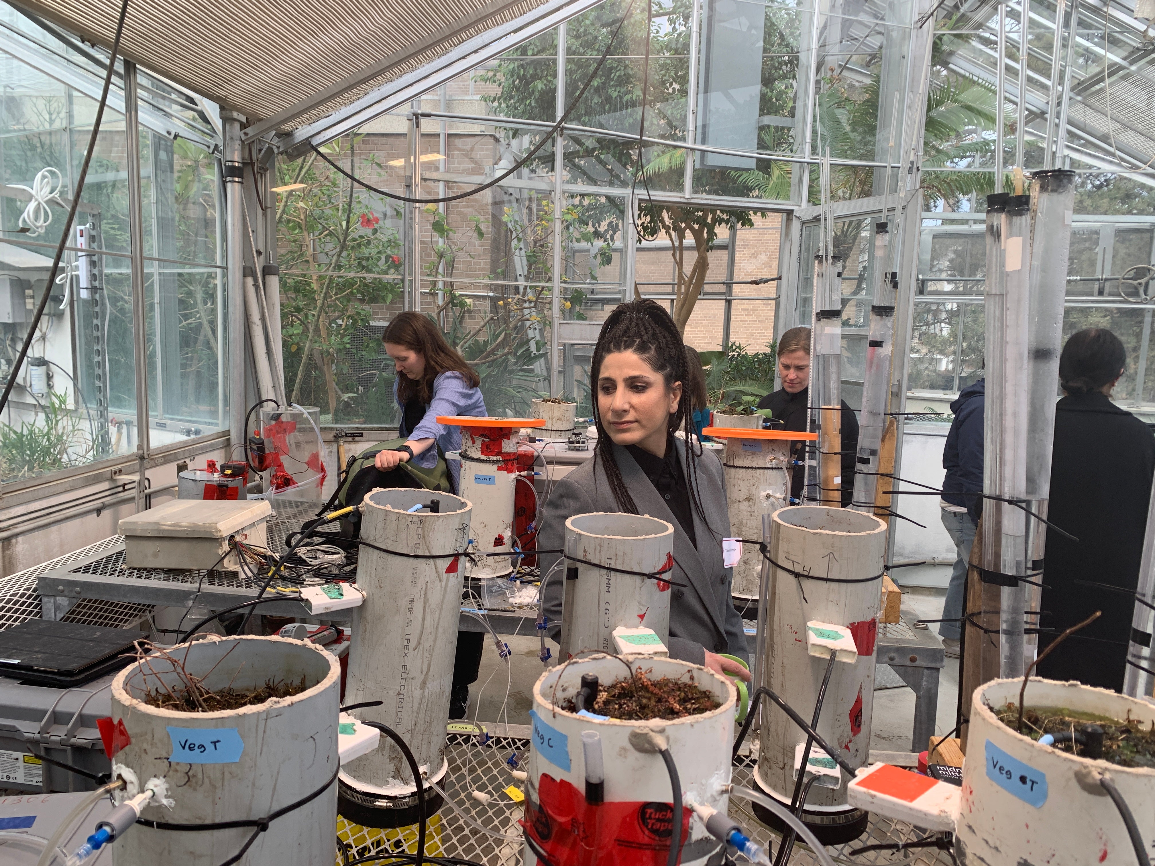 Workshop participants take an up-close look at the methane flux gas chamber experiments. 