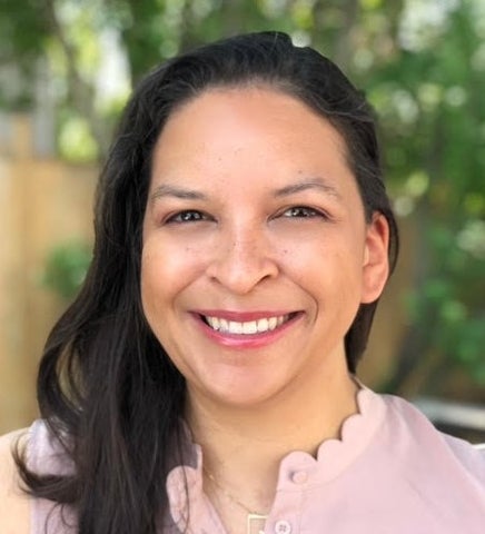 photo of Natasha Ivanochko, wearing a pink collared shirt and smiling. 