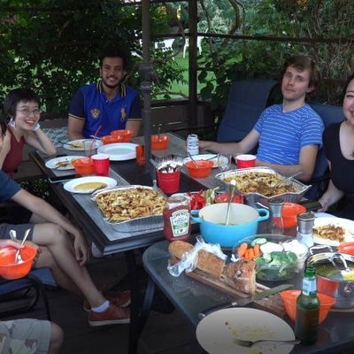 A group of people sitting around the table in the backyard