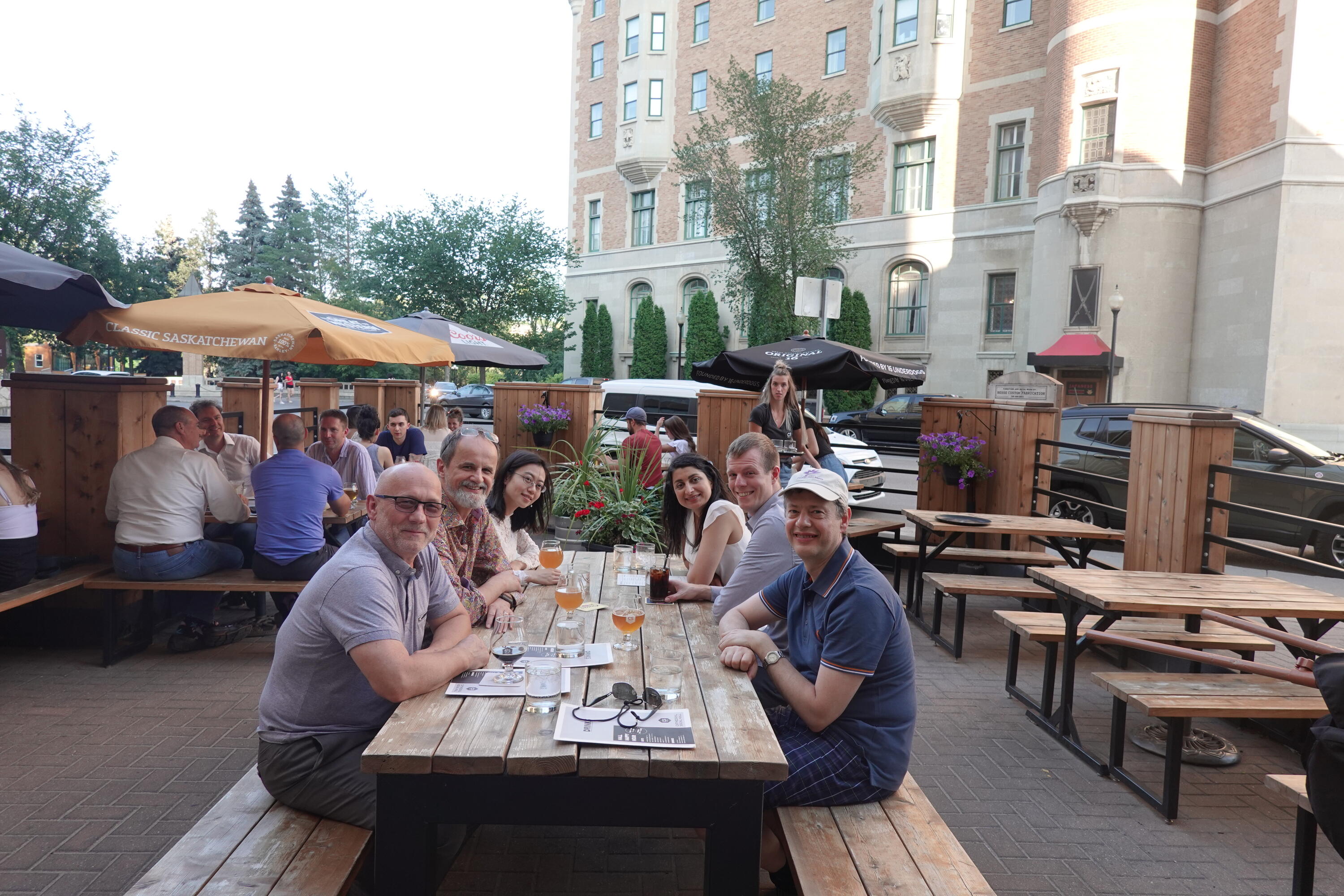 A group of people sitting around a table on the restaurant patio