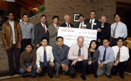 Holding the "large" cheque presented by  Leitch Technology Corp. are (from left to right) Director of the Multimedia Communications Laboratory, Prof. En-hui Yang, UW President David Johnston, and Letich's CTO Stan Moote. Standing left to Prof. Yang is ECE Chair, Prof. Tony Vanelli.