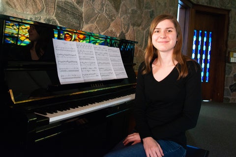 Leah sitting at the piano smiling into camera