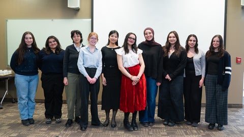 group of students posing together in front of projector screen