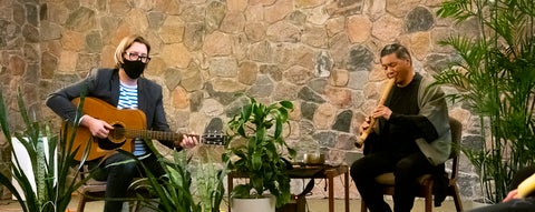 Two musicians playing a guitar and a flute
