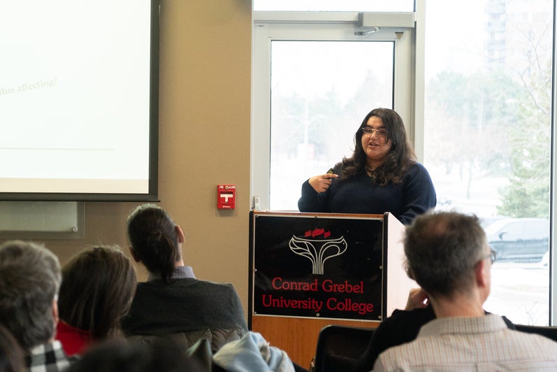 Serin Enver standing at podium looking onto a crowd