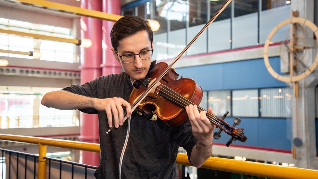 Shayan playing his violin in DC library