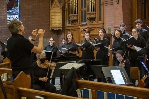Mark Vuorinen on left conducting Chamber Choir in a church