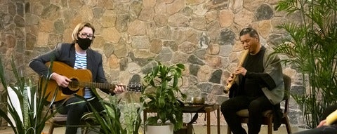 Two musicians playing a guitar and a flute